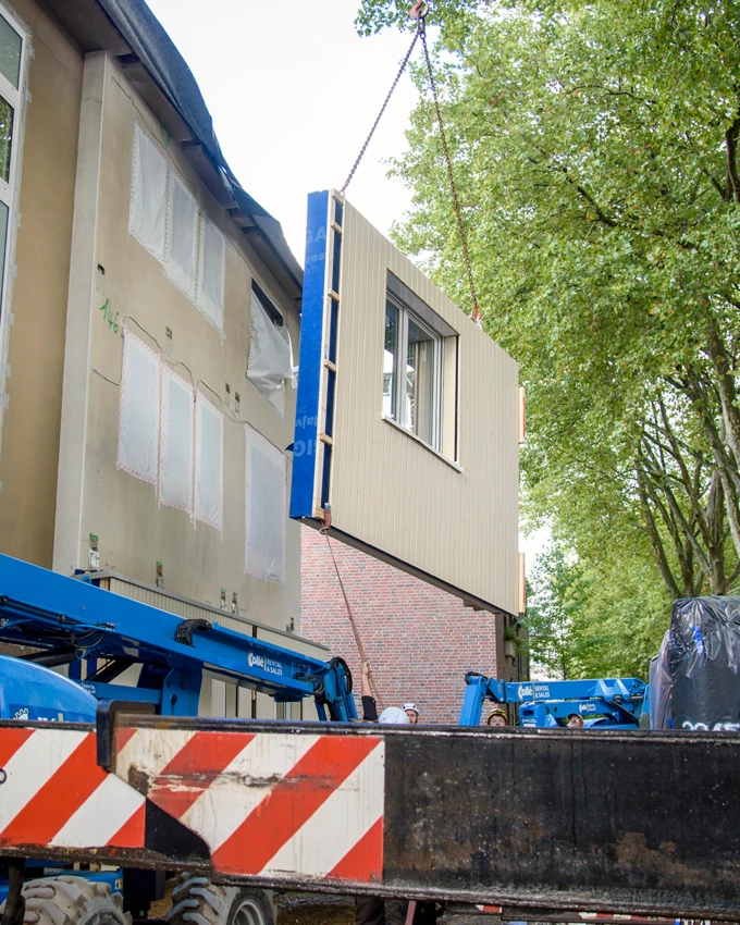 Sanieren in Serie: Am gestrigen Donnerstag wurde die erste Großflächenpaneele für die Fassadenisolierung am Pilotprojekt der Renowate GmbH montiert.